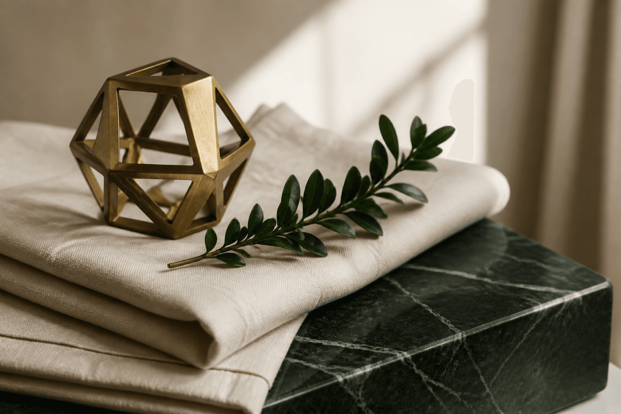 Editorial still life with brass, linen, and forest-green marble